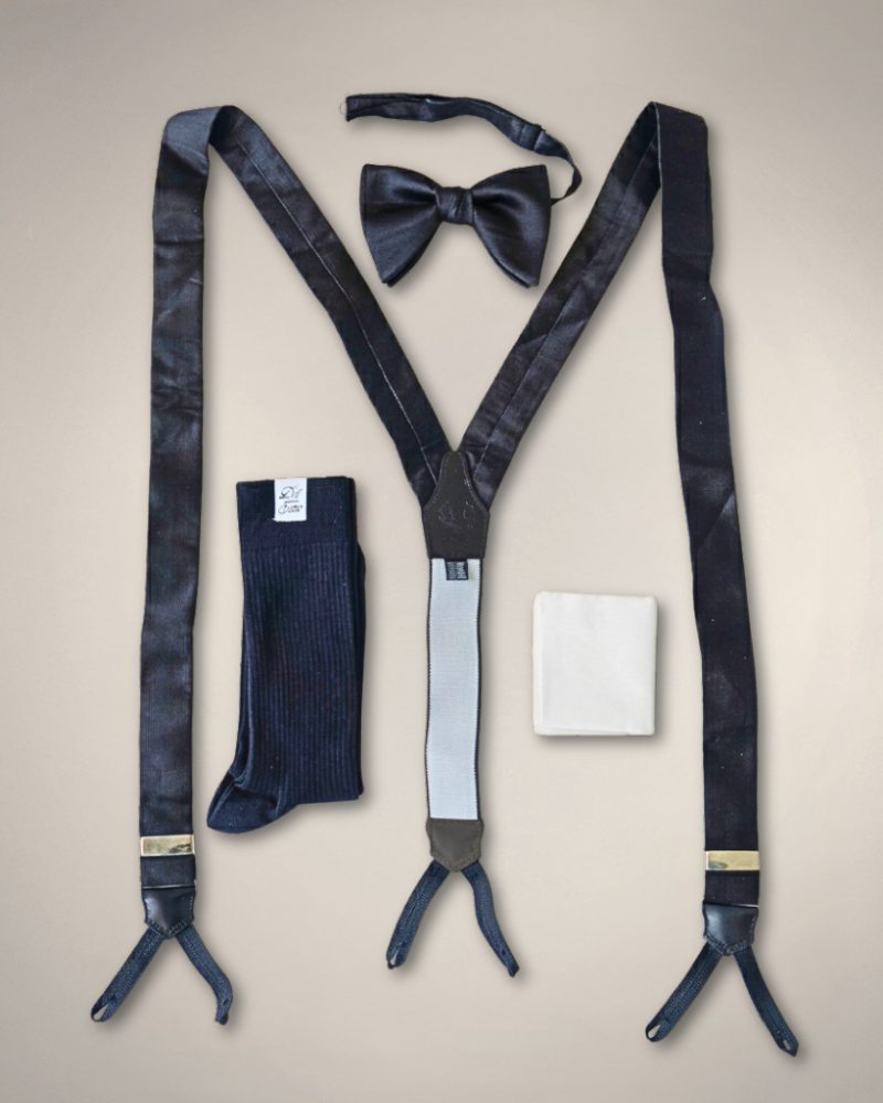 overhead shot including black silk suspenders, navy blue ribbed socks, white cotton pocket square, & a black silk bow tie