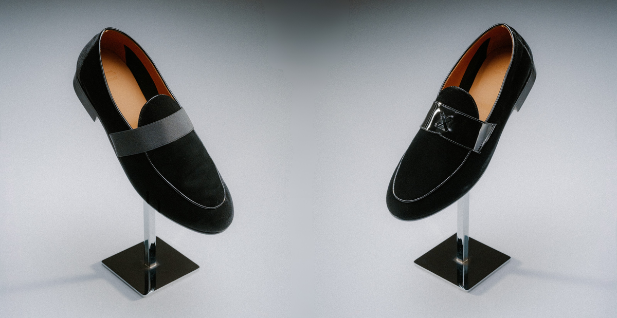 Black velvet loafers propped up on a shoe stand